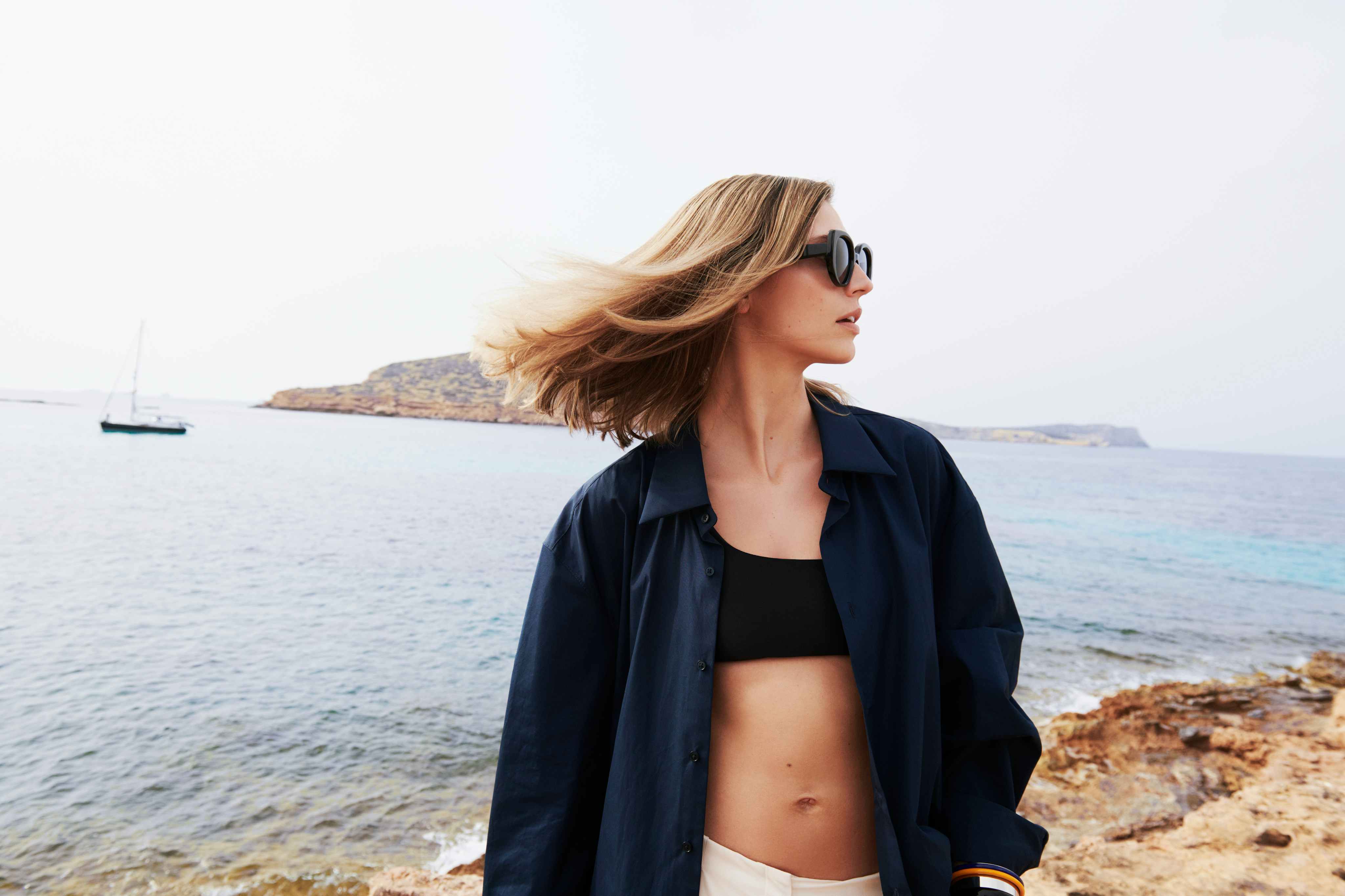 Woman with windblown hair by the sea